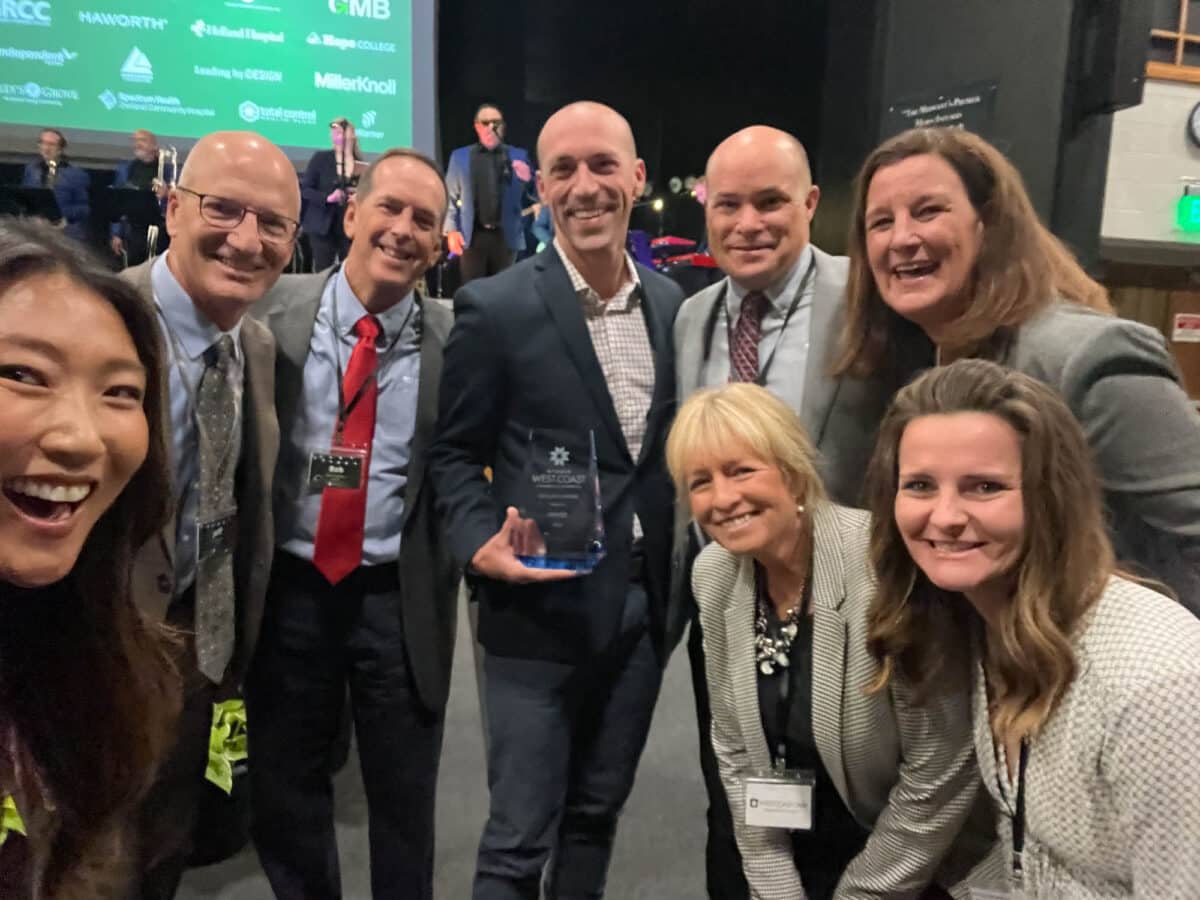 A group of leaders from DISHER smile with an award for innovation