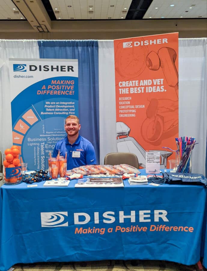 A DISHER recruiter sits at a career fair booth