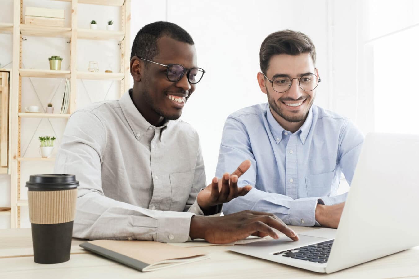 Two people sitting at a computer talking